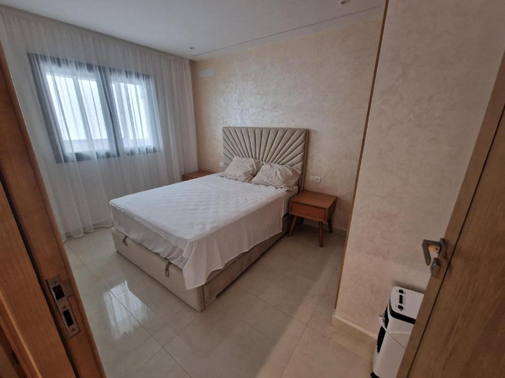 een kleine slaapkamer met een bed en een raam bij Luxe Appartement in Tetouan in Tetouan