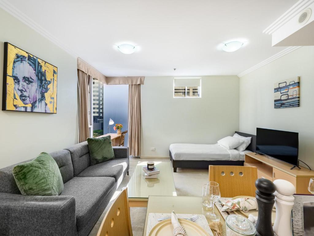 a living room with a couch and a table at Good Value Convenient City Central 2BR Apt in Brisbane