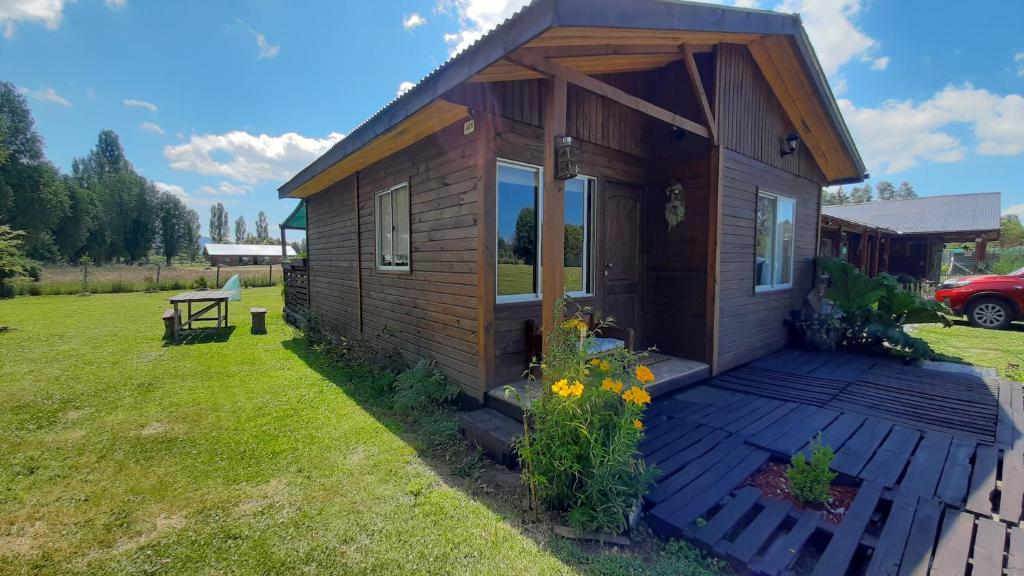 a tiny house on a deck in a yard at ENTRE PINOS Y LUCEROS ACOGEDORA CABAÑA RÚSTICA in Villarrica