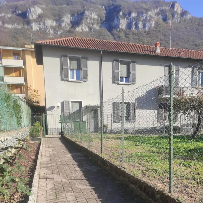 a fence in front of a house with a building at Casa Zia Luisa in Lecco
