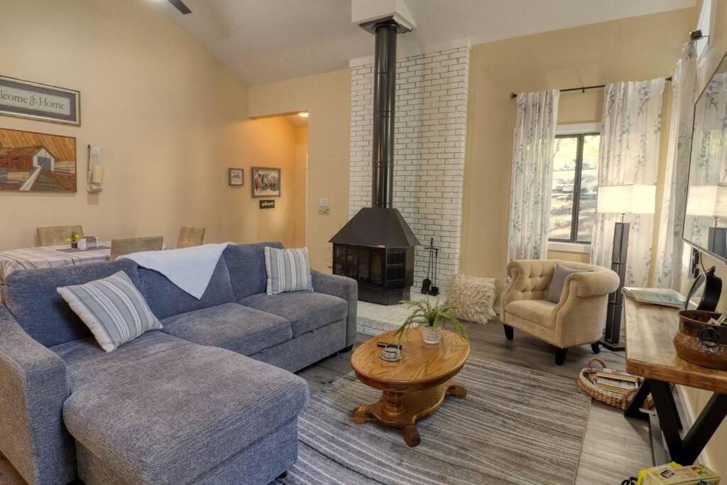 a living room with a blue couch and a fireplace at Bryce Chalet Retreat A Mountain Getaway in Basye