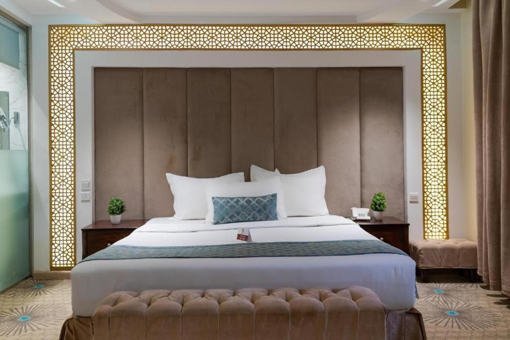 a bedroom with a large bed with a large headboard at Holiday Plus Al Salamh- هوليداي بلس السلامه in Jeddah