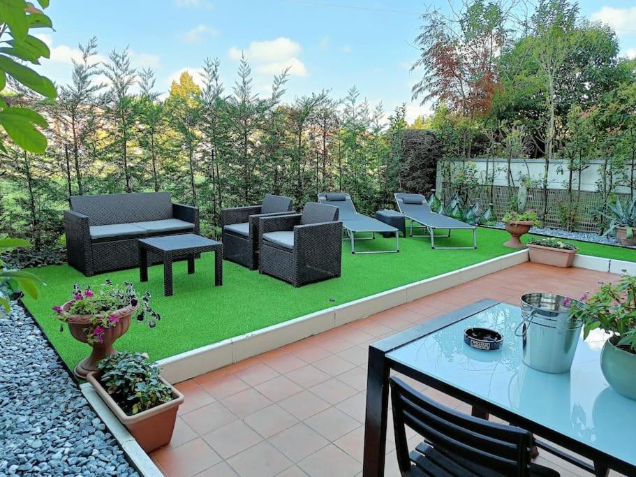 un patio con sofás, mesa y sillas en Art-Apart LT appartamento con giardino privato en Padua