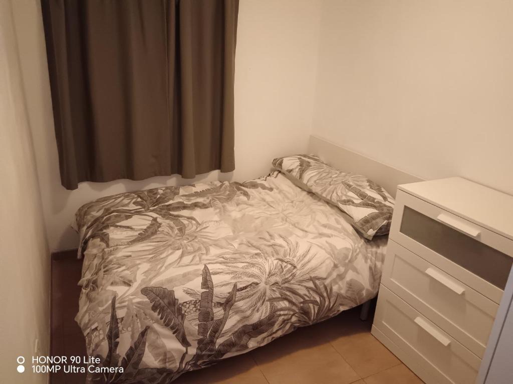 uma pequena cama num pequeno quarto com uma cómoda em Castellón Apartment Basic em Castellón de la Plana