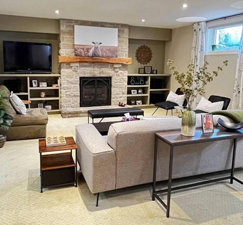 a living room with a couch and a fireplace at Farmhouse Apartment Guelph Elora in Guelph