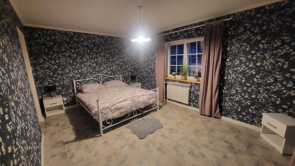 um quarto com uma cama com papel de parede floral em Bieszczadzkie Wspomnienie Lawendowy Dwór em Paszowa