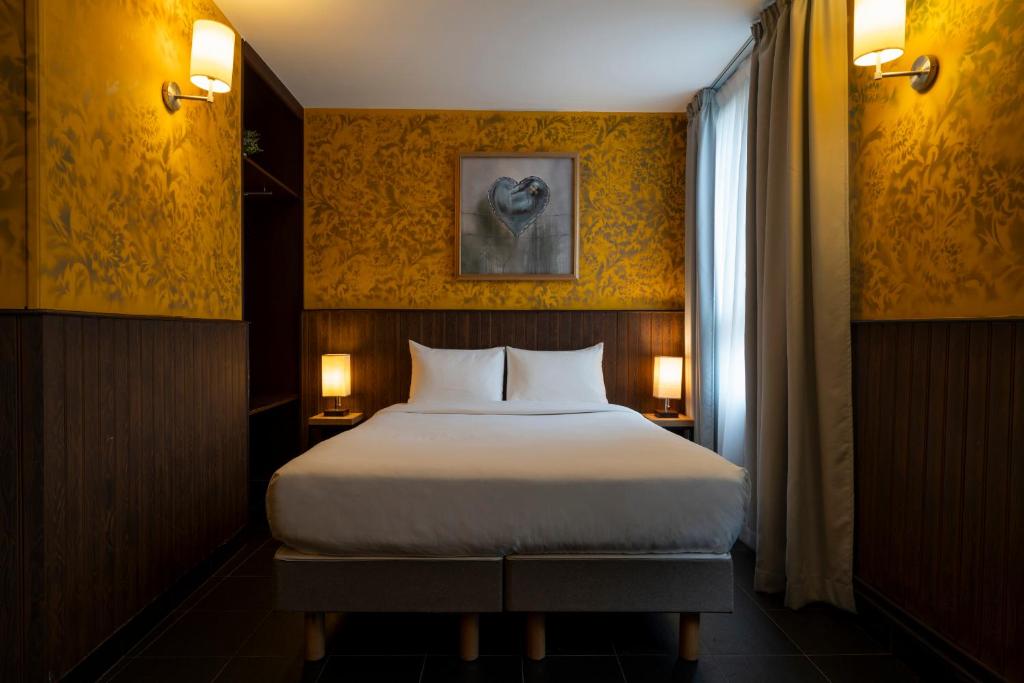 - une chambre avec un grand lit et une fenêtre dans l'établissement Walled off Hotel Paris, à Paris