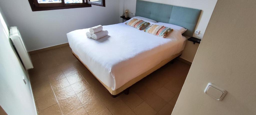 a small bedroom with a bed with white sheets and pillows at Apartamento Minairons Espot in Espot