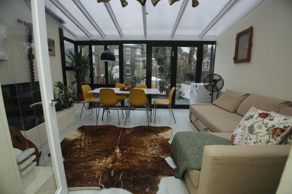 ロンドンにあるCOSY CAMDEN 2 BEDROOM APARTMENT WITH TERRACEのリビングルーム(ソファ、テーブル、椅子付)