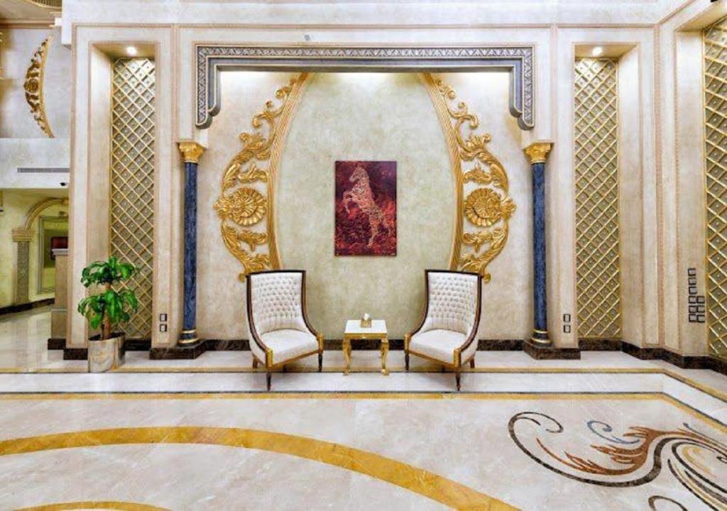 a lobby with two chairs and a table and a painting at SANSA HOTEL in Jeddah