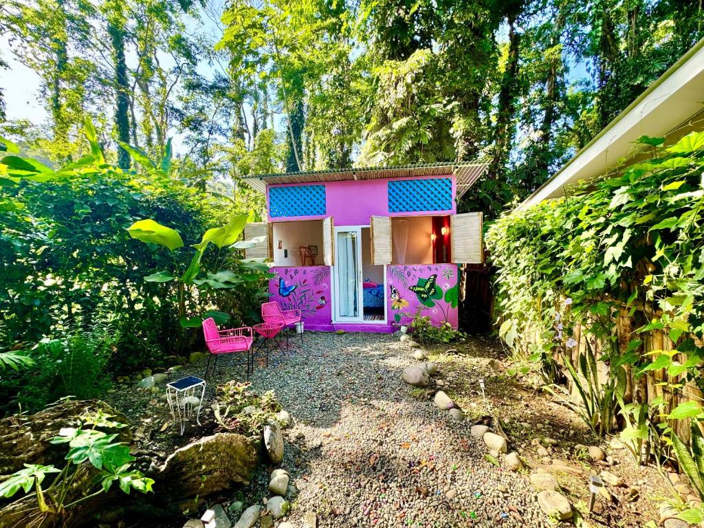 a house with a purple door and pink chairs at Casa Mariposa in Puerto Viejo