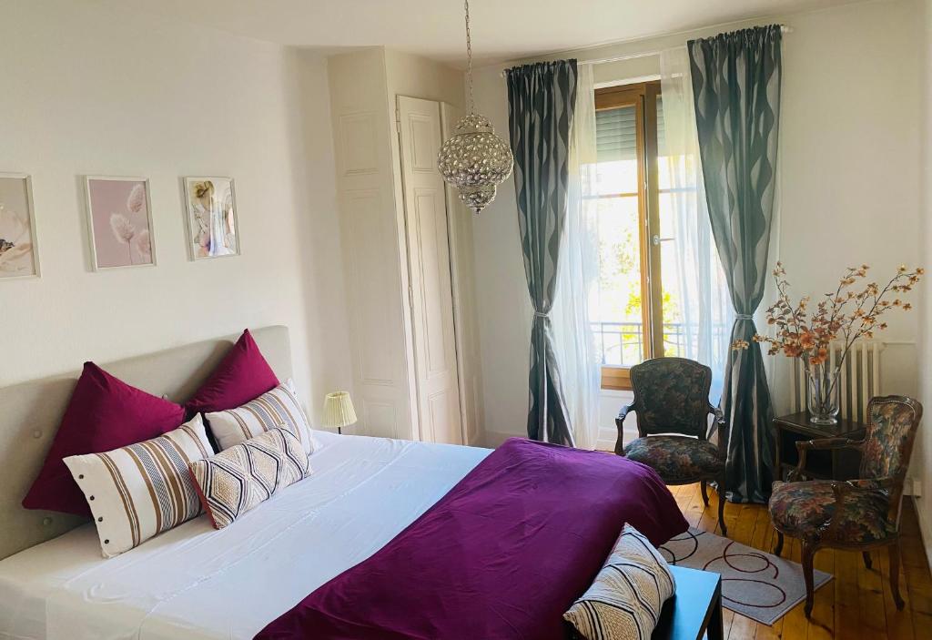 1 dormitorio con 1 cama grande con sábanas moradas en HOCORAS Apartment en Ginebra
