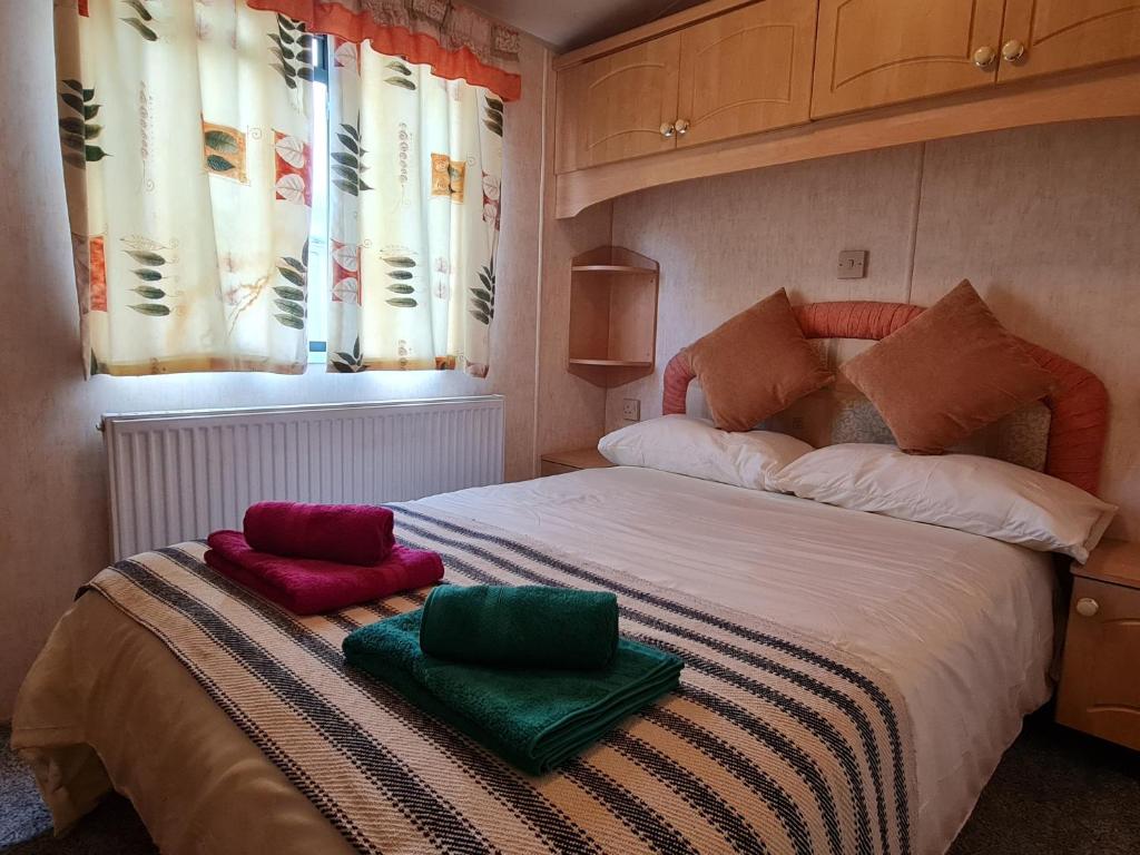 1 dormitorio con 1 cama con 2 almohadas en Willerby Holiday Home, en Durham