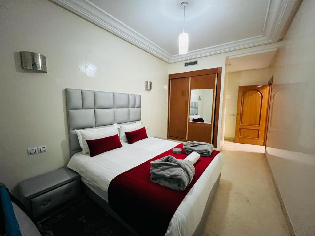 1 dormitorio con 1 cama grande con almohadas rojas en Chez Alex en Marrakech