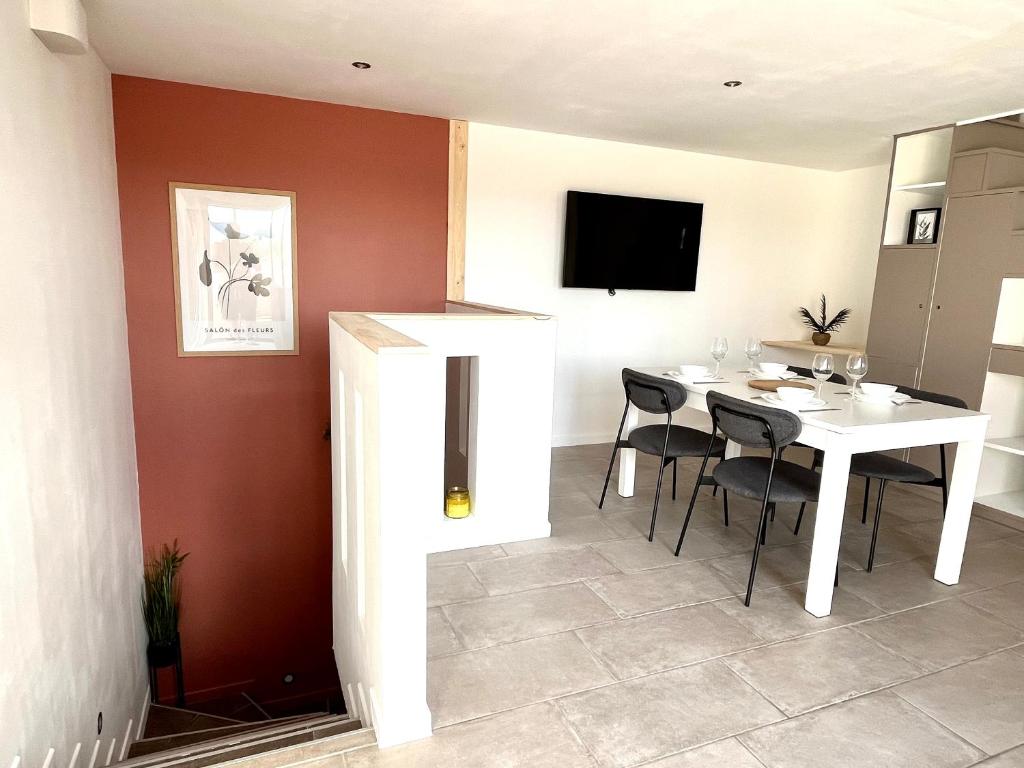 une salle à manger avec une table et des chaises blanches dans l'établissement Chaleureuse maison avec terrasse et garage, à Espira-de-lʼAgly