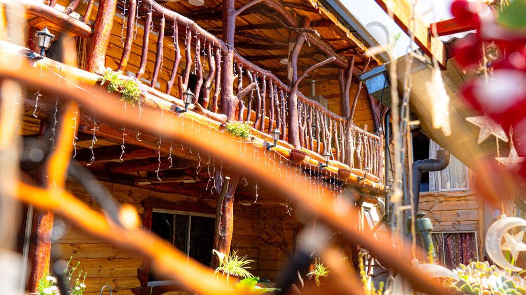 ein Holzgebäude mit einem Balkon mit Pflanzen in der Unterkunft Hostal Central Panguipulli in Panguipulli