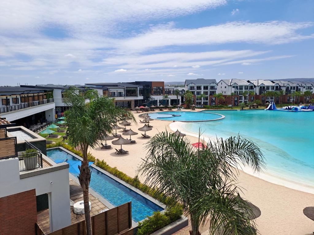 an aerial view of a resort swimming pool with palm trees at THE BLYDE Holiday Apartments in Pretoria