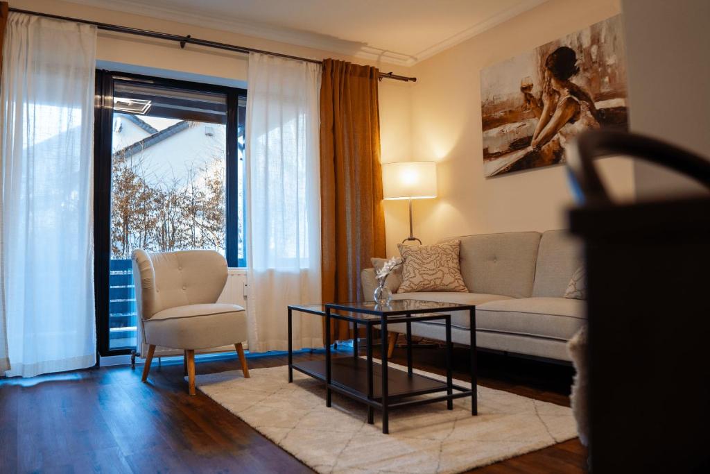 ein Wohnzimmer mit einem Sofa und einem Tisch in der Unterkunft Apartment SiLa in Kassel