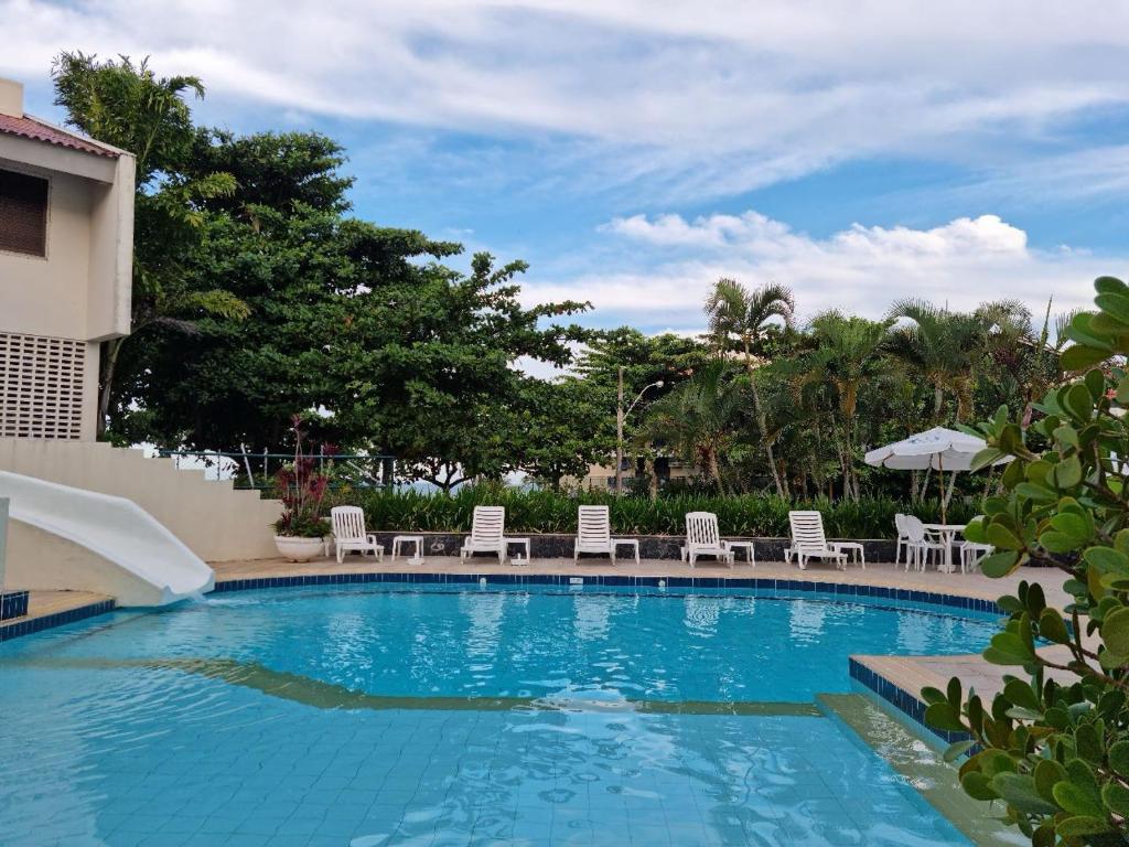 uma piscina com cadeiras e guarda-sóis num resort em Praia Brava Hotel em Florianópolis