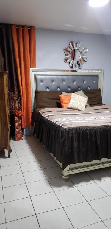 um quarto com uma cama com uma cortina laranja em Large Gated King Bed Apartment in Central Kingston em Kingston