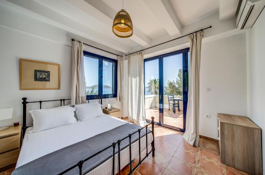 a bedroom with a bed and a large window at Villa Salanti in Koilás