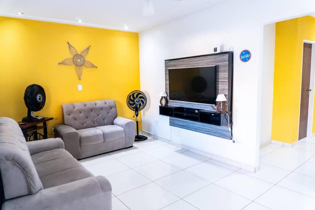 een woonkamer met twee banken en een tv bij PV Marimbondo's House I in Itacaré