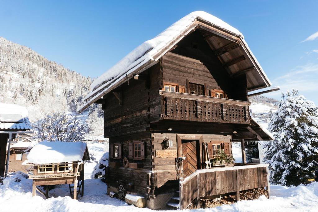 eine Blockhütte mit Schnee auf dem Dach in der Unterkunft Bio Naturhof Ottingerhof in Bad Kleinkirchheim