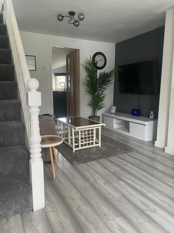a living room with a staircase and a television at “1-Bed Haven in Snowdonia nr ZipWorld, Snowdon” in Blaenau-Ffestiniog