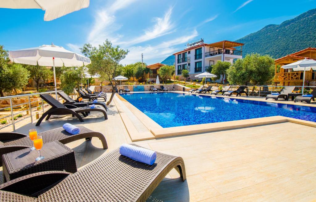 a pool at a hotel with tables and chairs at Doganın Ruhu Hotel & Bungalow in Kas
