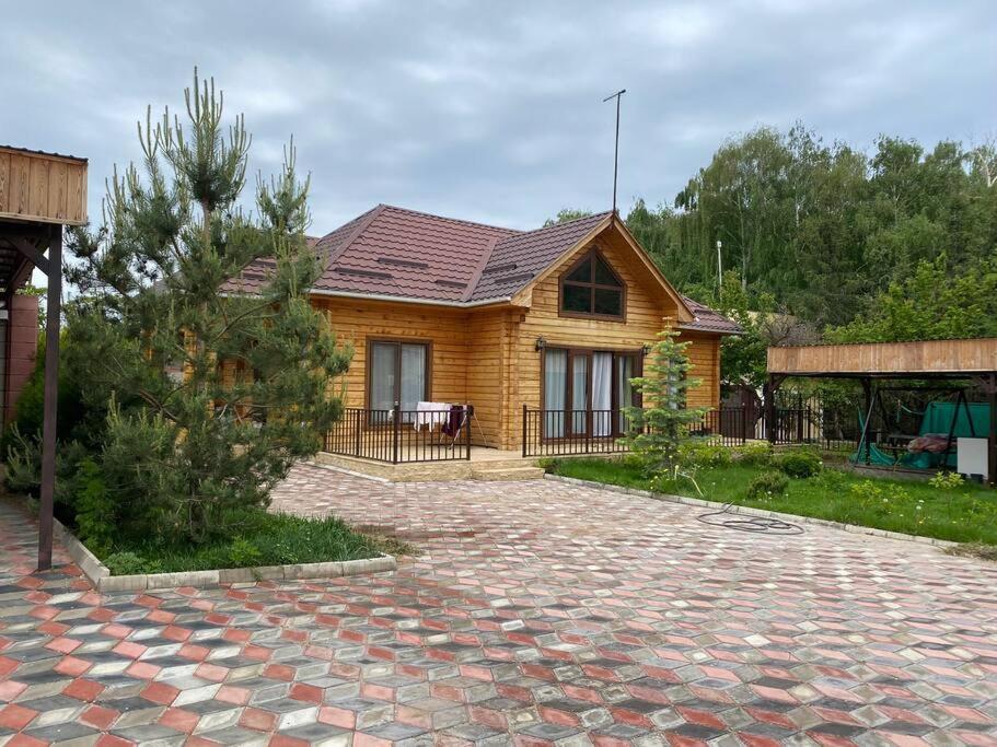 a wooden house with a brick driveway in front of it at Сруб на Иссык Куле in Chon-Sary-Oy