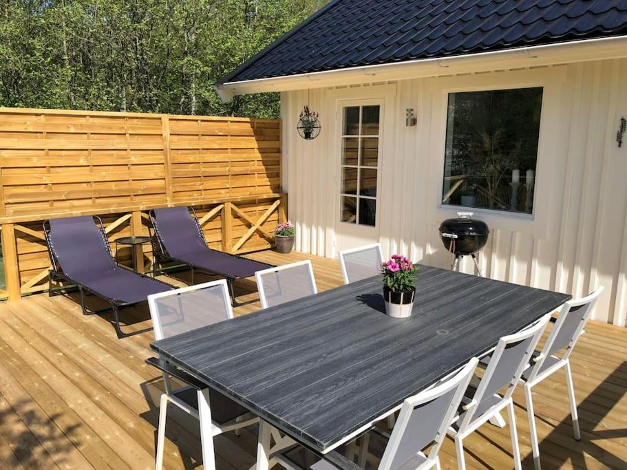 une table et des chaises noires sur une terrasse en bois dans l'établissement Modern house on the countryside in lovely Bohuslän, à Uddevalla