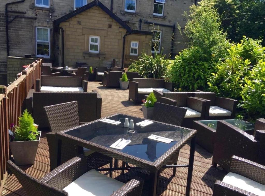 a patio with tables and chairs in front of a building at Armstrong Manor in Rothbury