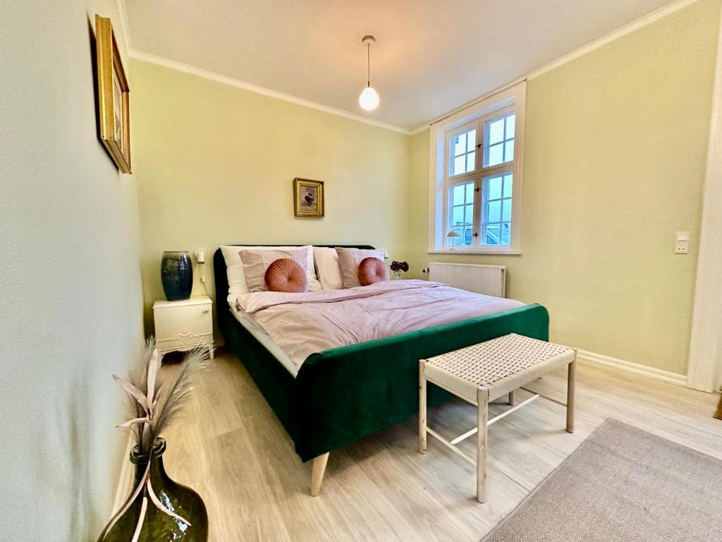 a bedroom with a green bed with a window at Hirtshals Gamle Station in Hirtshals