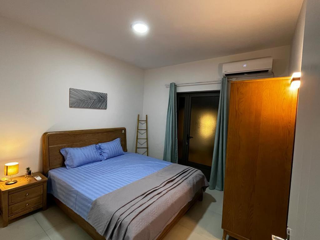 a bedroom with a bed and a dresser and a window at Les Olives in Flic-en-Flac