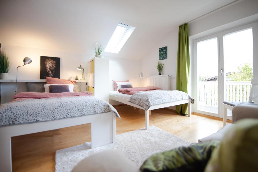 - une chambre avec deux lits et un canapé dans l'établissement Einzigartige Auszeit mit Bergblick in Bad Tölz, à Bad Tölz
