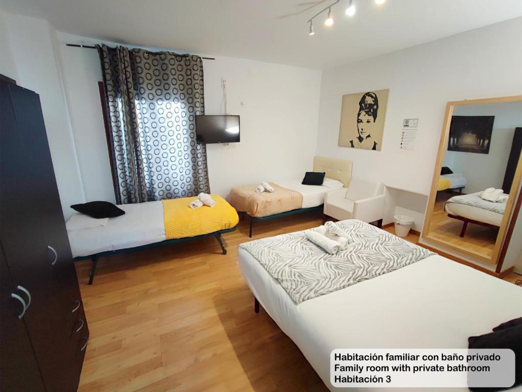 a room with two beds and a living room at Madrid Centro Rooms in Madrid
