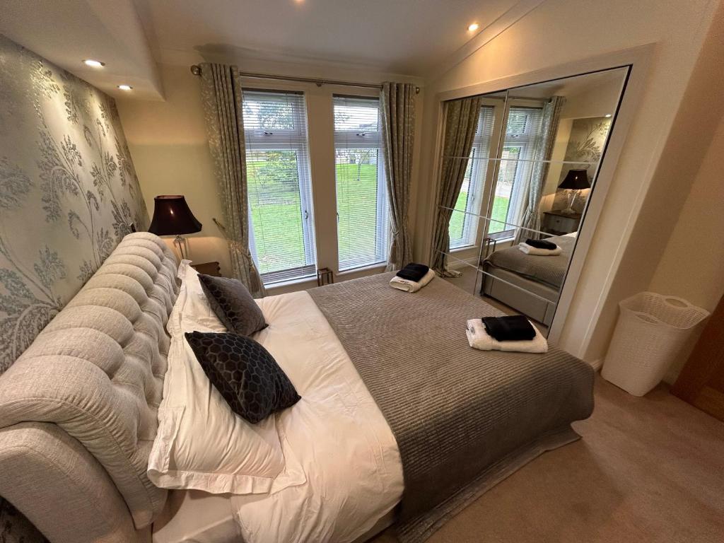 a bedroom with a large bed with a large mirror at Relaxing Woodland Retreat in Eaton