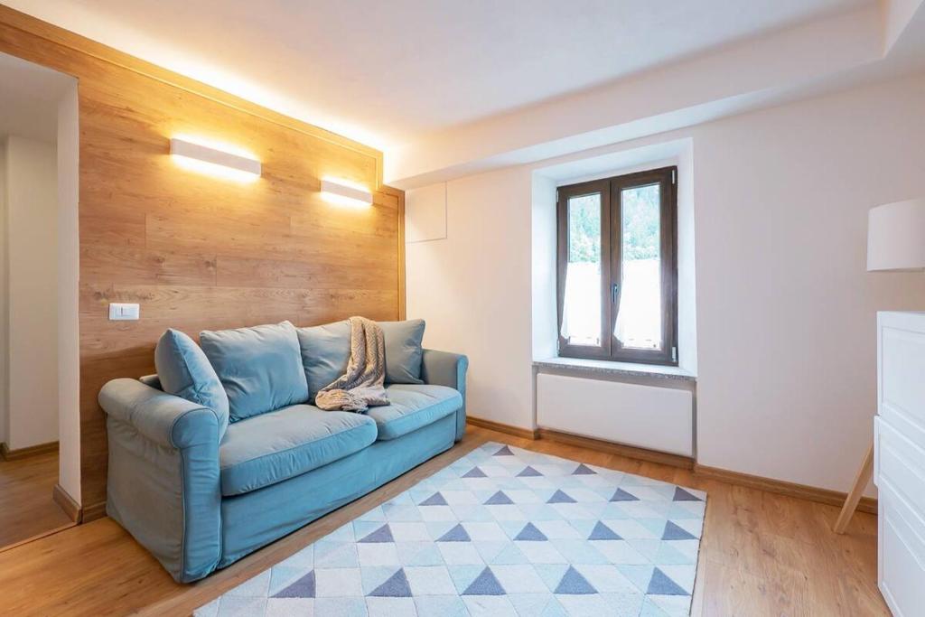 a living room with a blue couch and a window at [IHost Luxury Flat Bormio] - Centrale 69 in Piatta