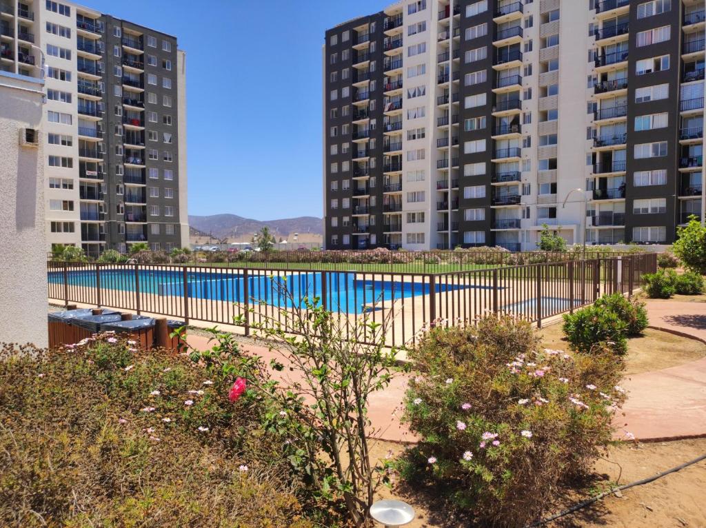 a swimming pool with two tall buildings in the background at Hermoso departamento in Coquimbo