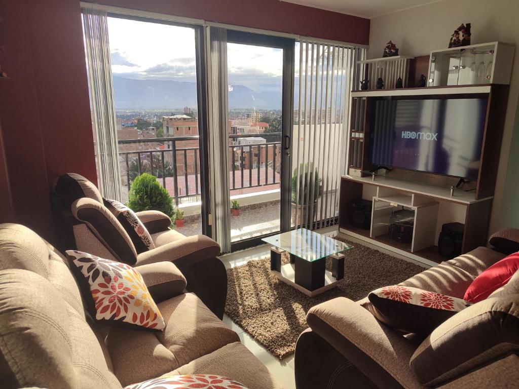 sala de estar con sofás, TV y balcón en Centro de la Ciudad - ¡a un paso de todo!, en Huancayo