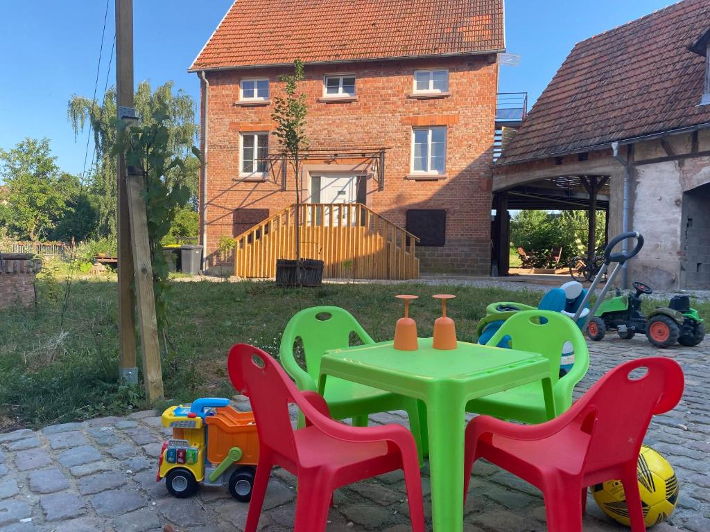une terrasse avec une table, des chaises et des jouets dans l'établissement Au clos du seltzbach, à Hoffen