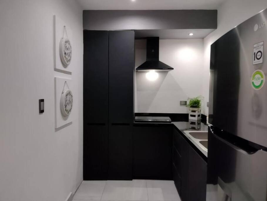 a kitchen with a black cabinet and a sink at Departamento en Heroica Matamoros in Matamoros