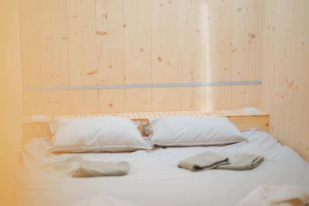 a white bed with two pillows and two gloves on it at Gonner Haus 