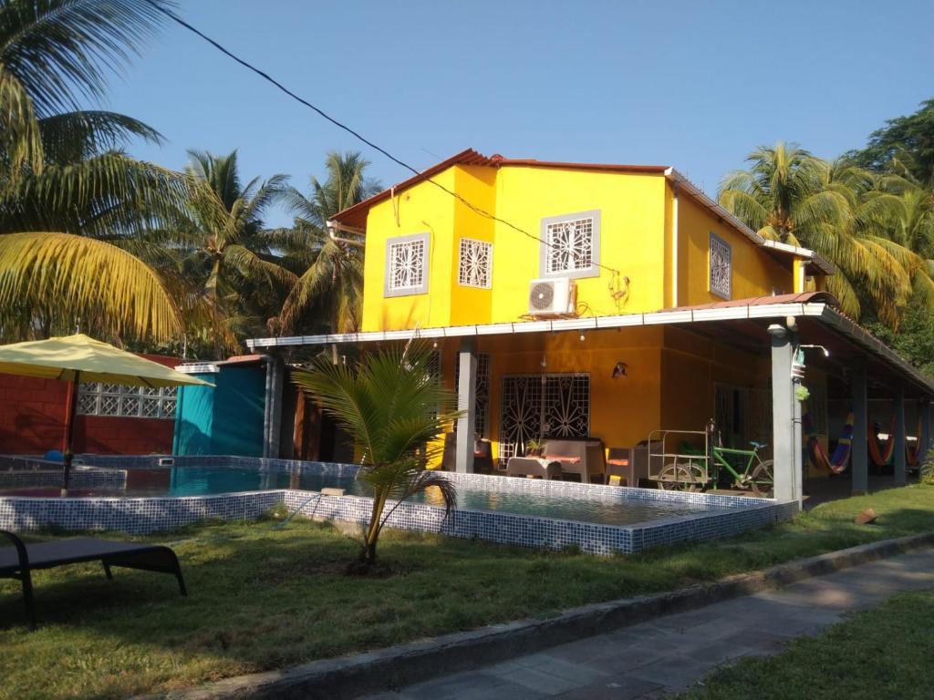 a yellow house with a pool in front of it at Casa para descanso familiar in San Pedro Masahuat