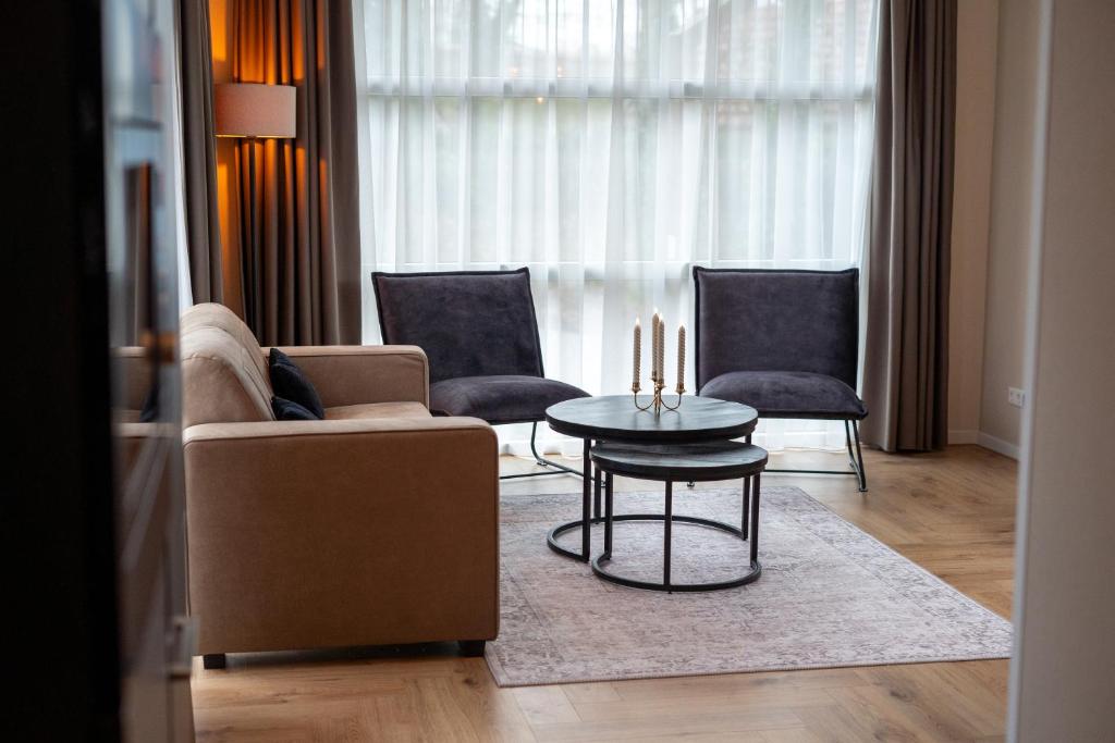 a living room with a couch and two chairs and a table at Huisje Novea in Harderwijk