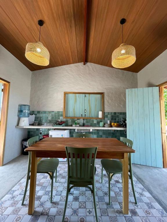 a kitchen with a wooden table and chairs at Casa Carol - Macapá Paradise in Luis Correia