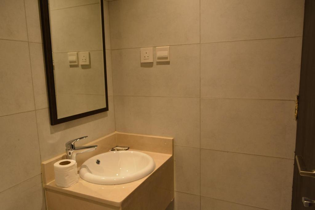 a bathroom with a sink and a mirror at فندق كنان العزيزية Kinan Al Azizia Hotel Makkah in Mecca