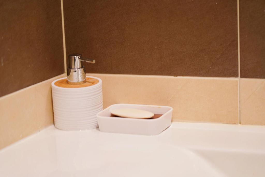 a bathroom sink with a soap dispenser and a toilet at Always on the way - Road Home in Montijo, Lisbon in Montijo