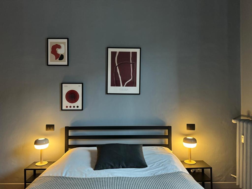 een slaapkamer met een bed en drie foto's aan de muur bij La Madama Cristina in Turijn