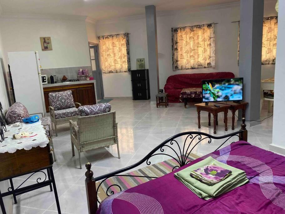 uma sala de estar com uma cama e uma televisão em joli studio à louer em Meknès